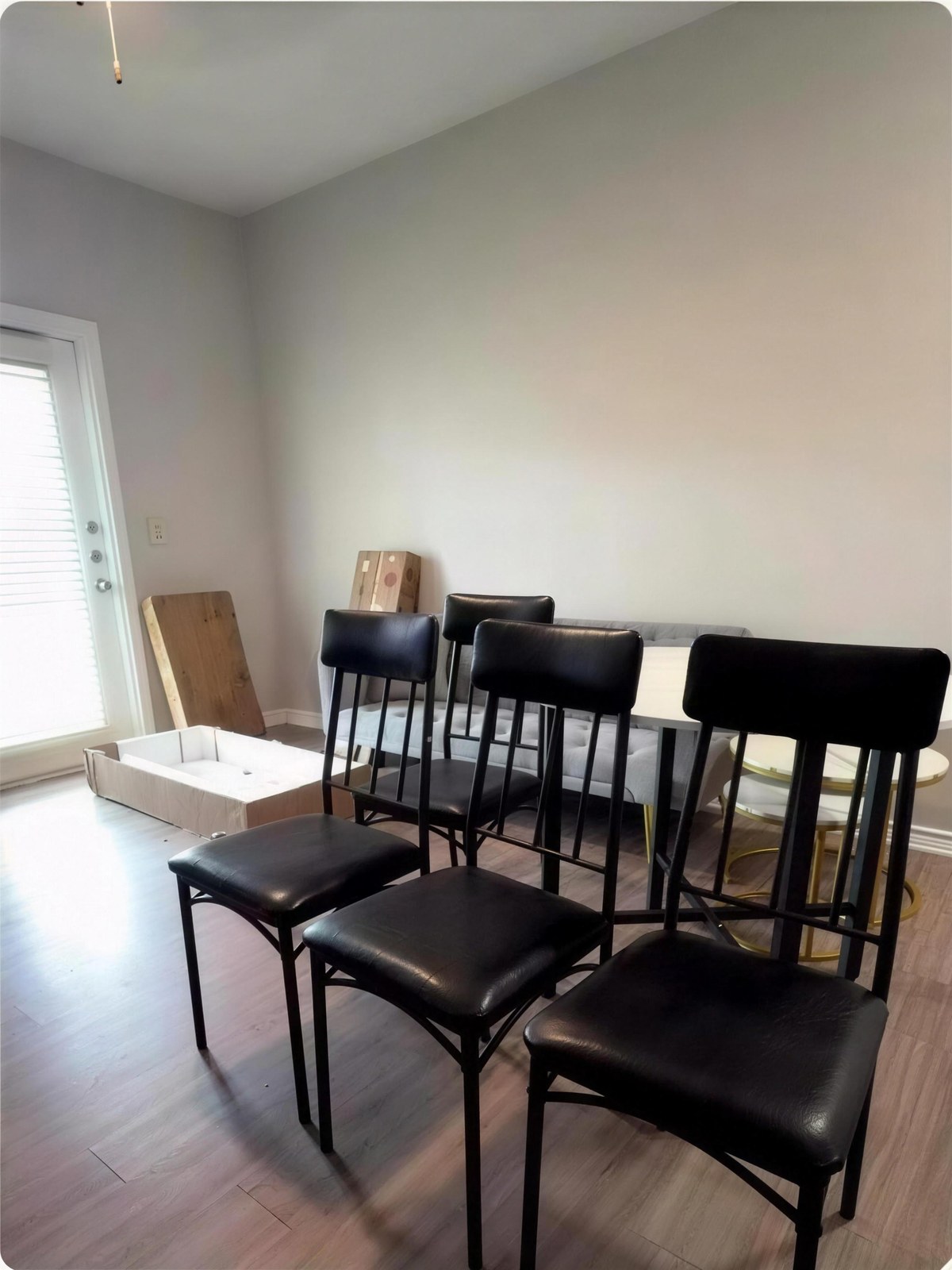 The same dining room with six assembled dining chairs and the table set in place.