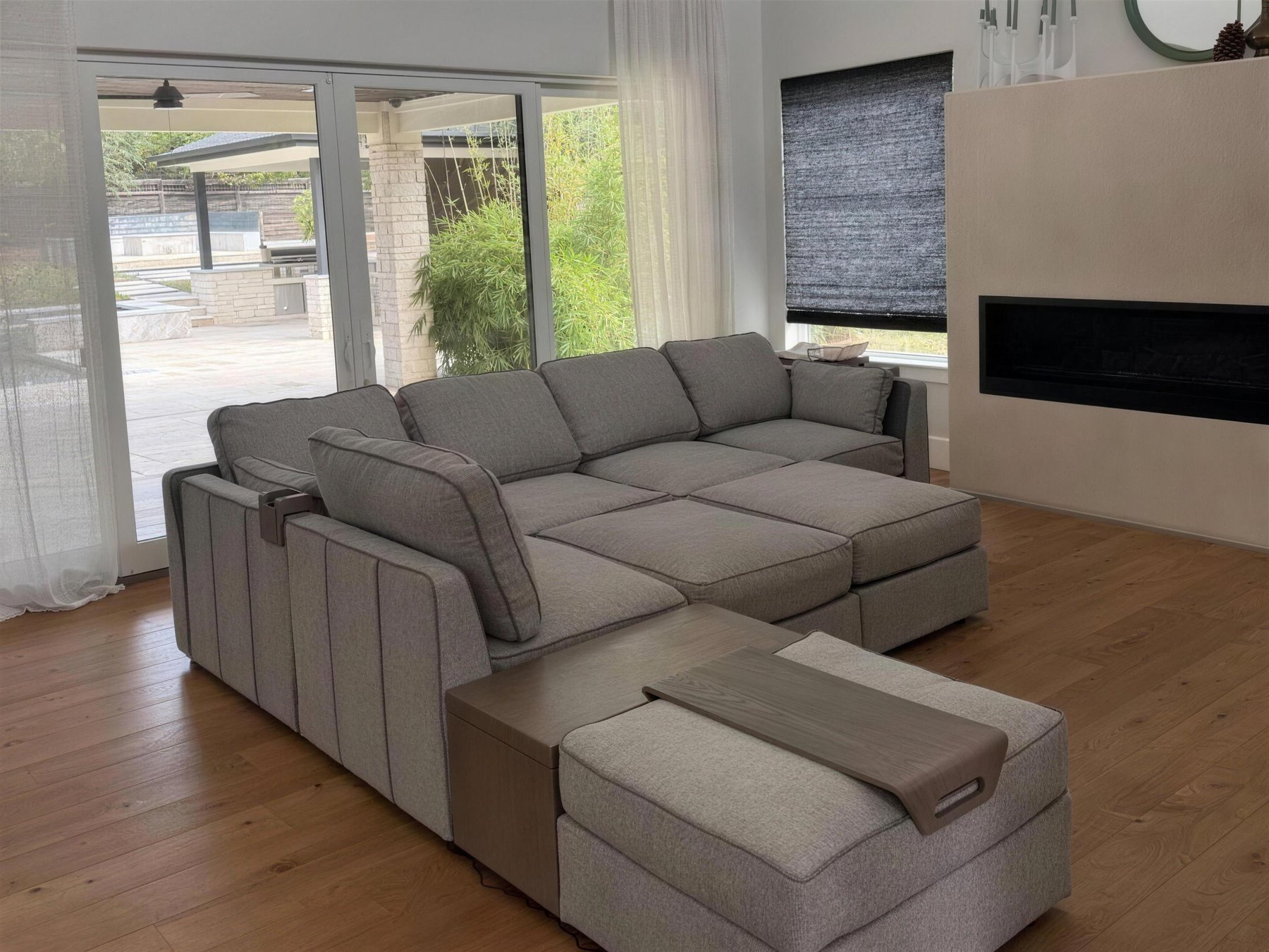 The same great room with the modular sectional and its ottomans assembled and placed facing the fireplace.
