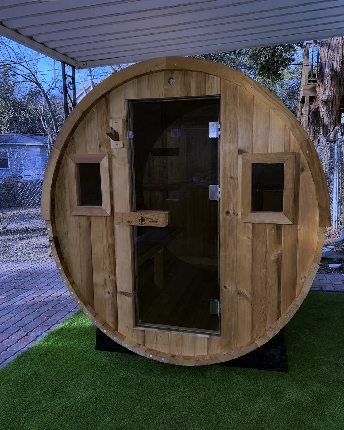 A barrel sauna assembled in a backyard.