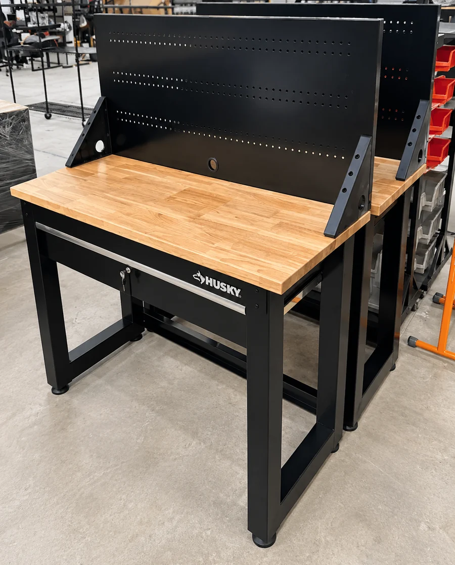 A steel-framed workbench with a timber top, assembled in a garage.