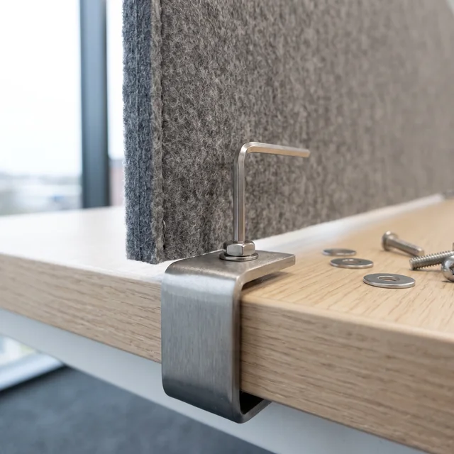 A bracket and its fixings being fitted to the edge of a worksurface.