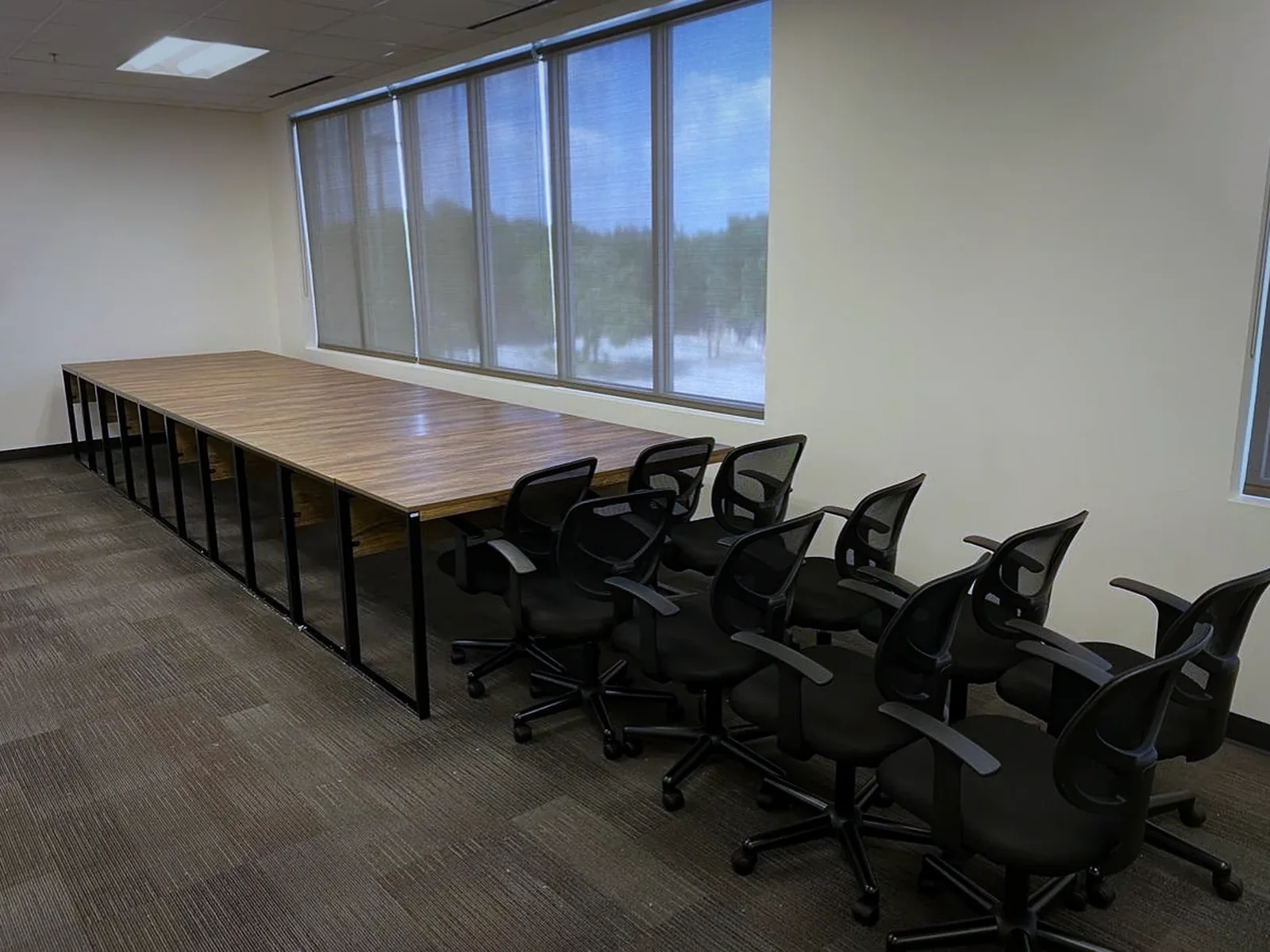 A finished row of training tables installed along an office window wall.